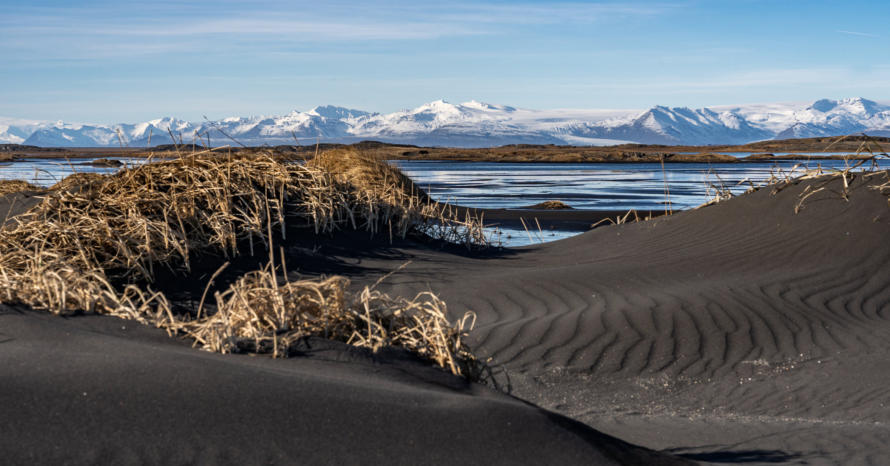 schwarze Dünen vor weißem Gletscher bei Stokksnes