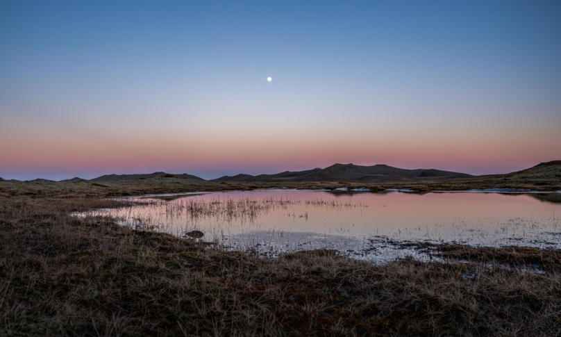 pastellfarbener Sonnenuntergang mit Vollmond irgendwo in Island