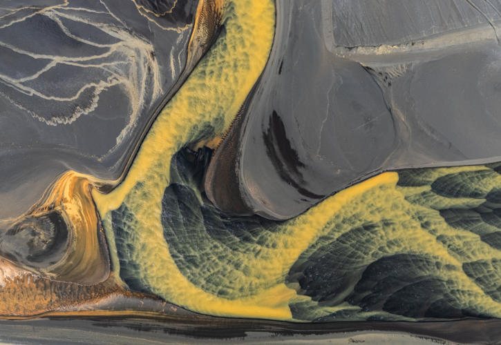 gelber Flussverlauf an schwarzer Sandküste